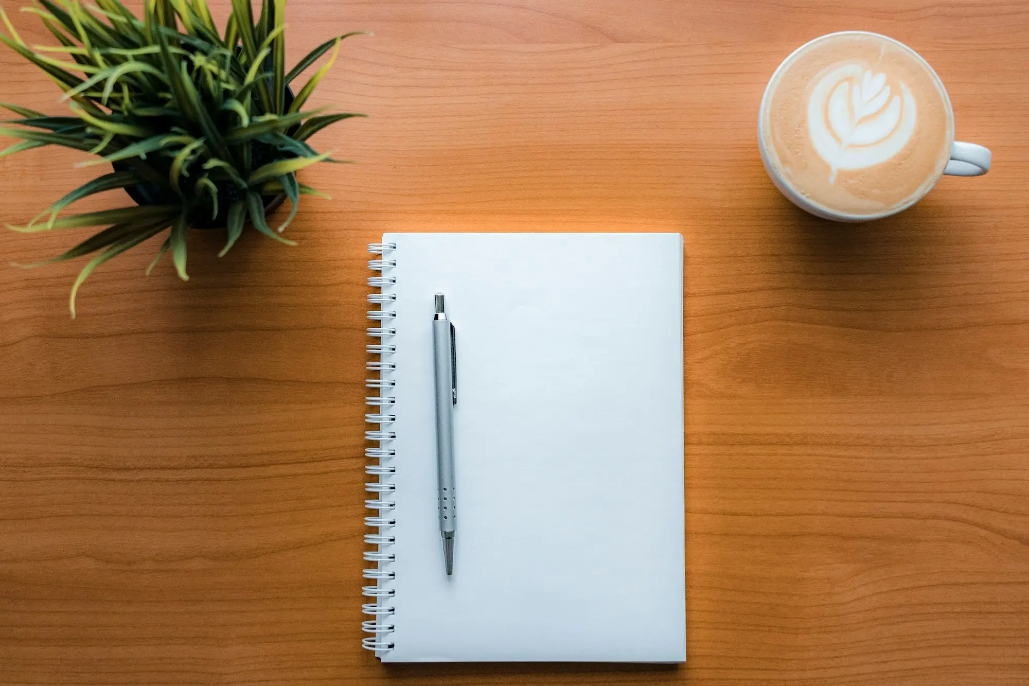 Pen and a cup of coffee on a desk while working through the numbers on a purchase