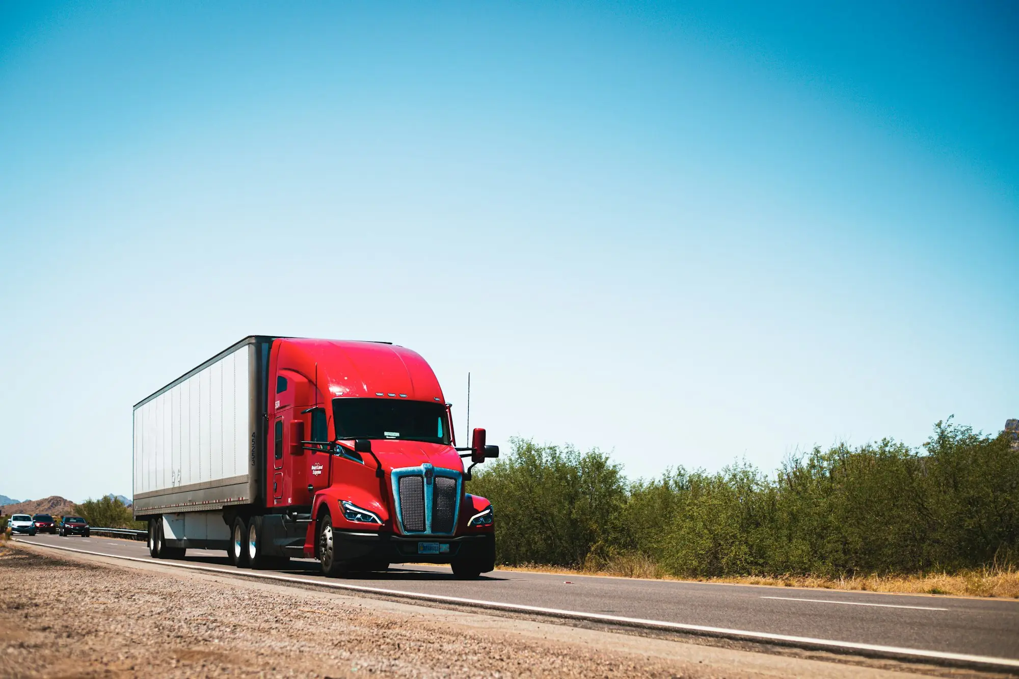 Red prime mover truck driving along a country road, a typical asset for truck finance
